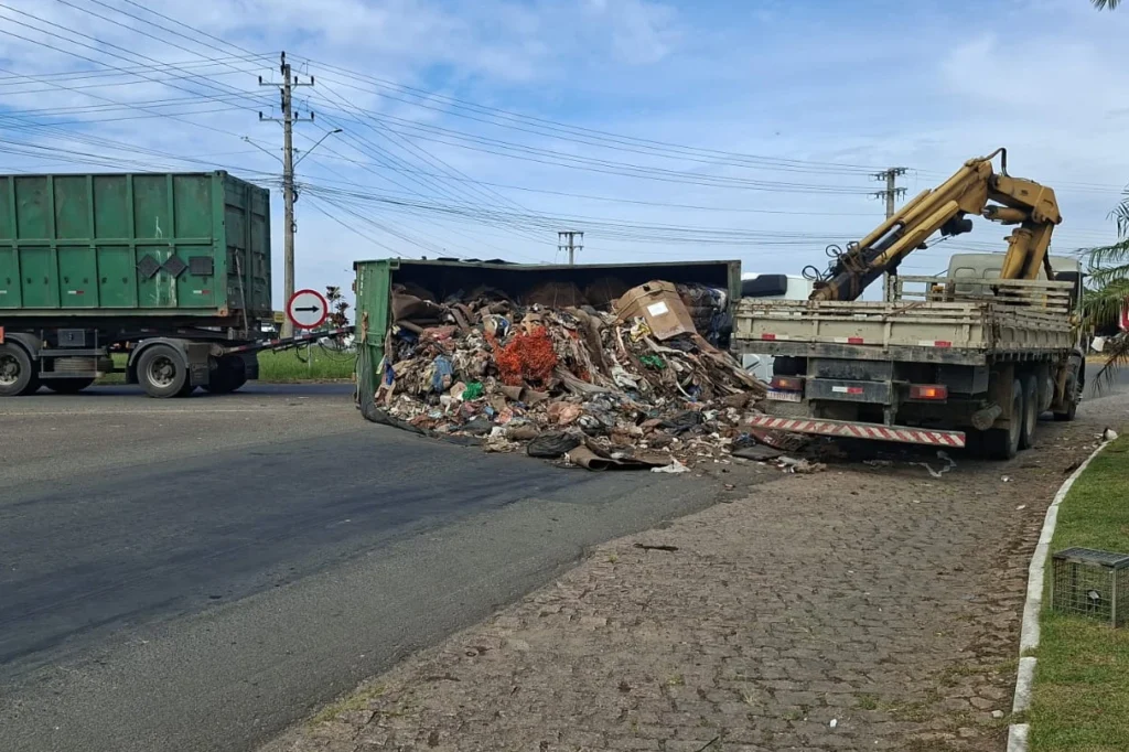 Contêiner carregado com recicláveis cai de caminhão em rótula da SC-443