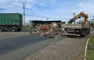 Contêiner carregado com recicláveis cai de caminhão em rótula da SC-443
